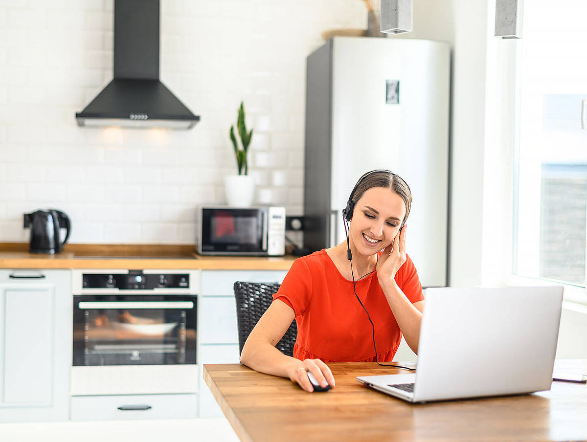 Nainen työskentelemässä tietokoneen ääressä keittiössä. Kuva: Shutterstock.