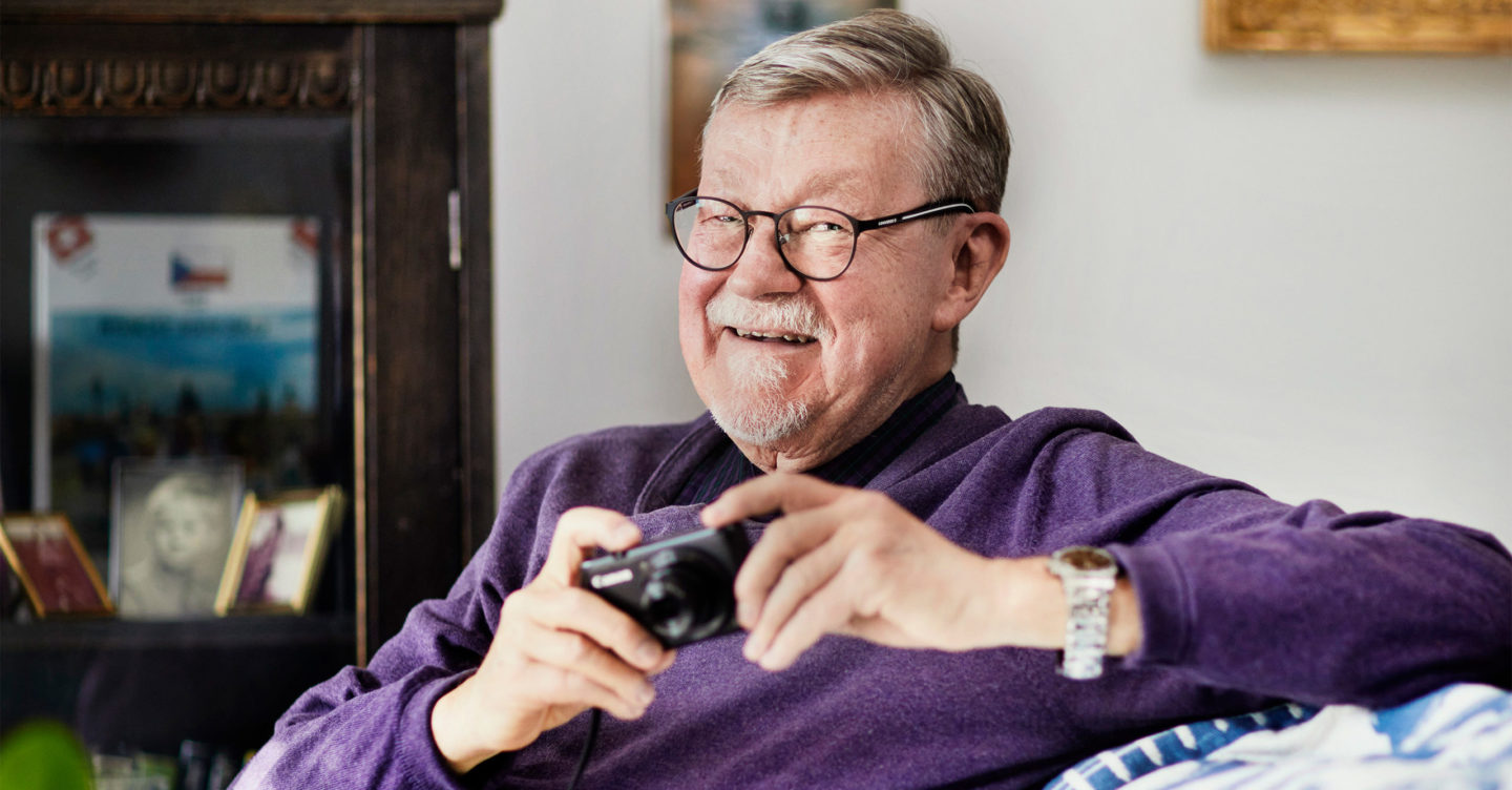 Ralf Holm kotisohvallaan kamera kädessä.