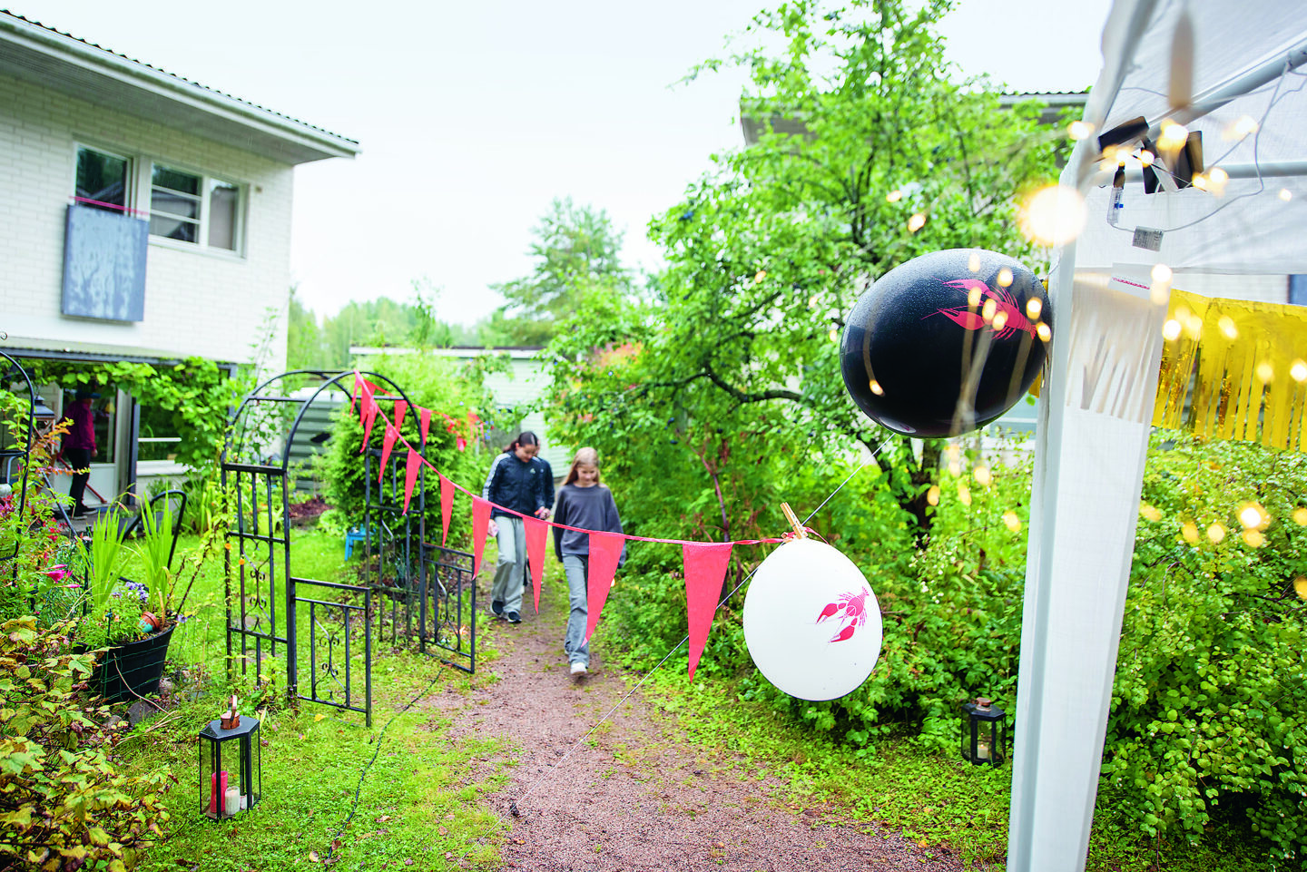 Lapset kävelemässä rapujuhliin pihalla.