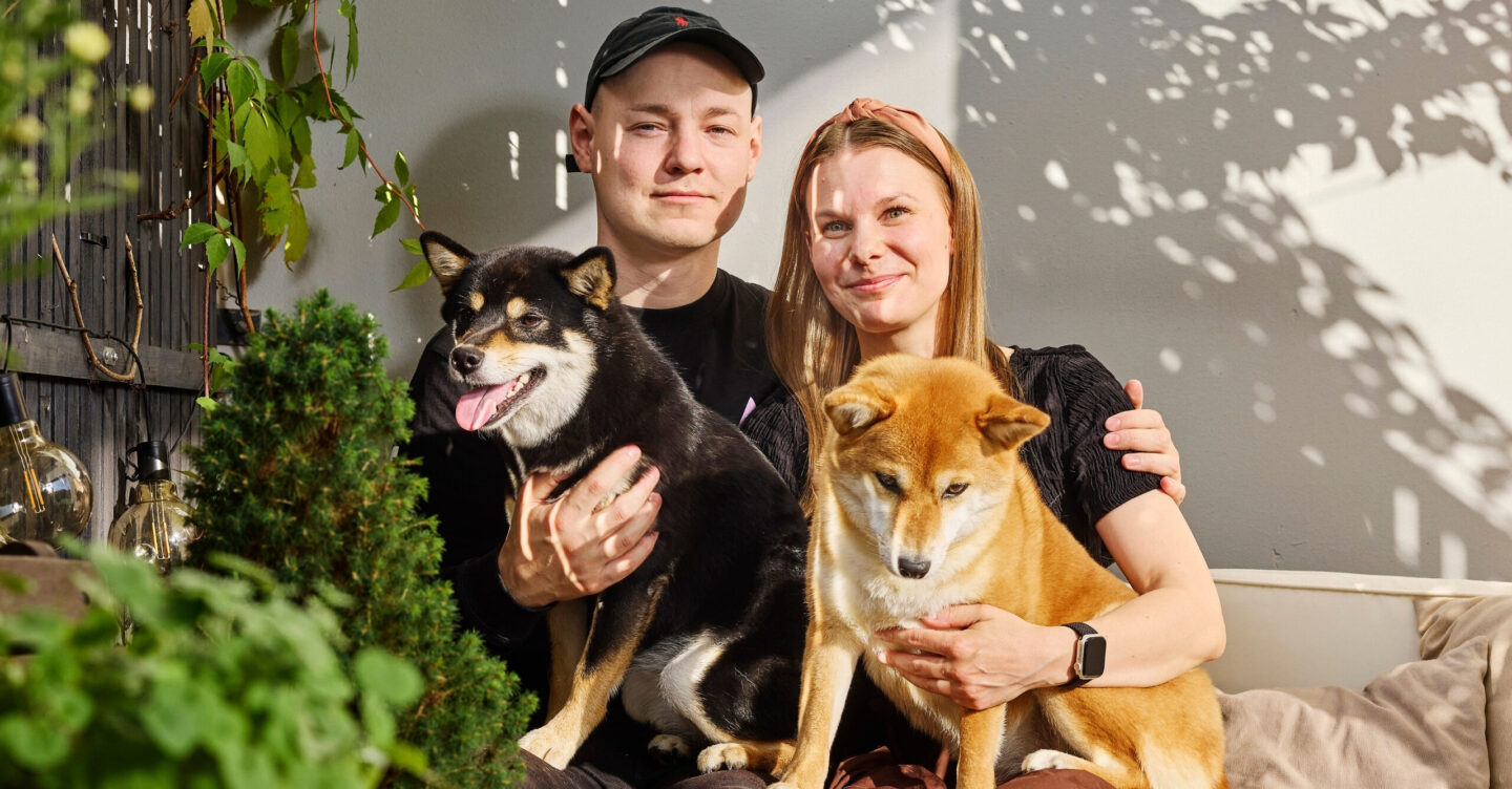 Mies ja nainen katsovat kameraan ja kummallakin on koira sylissään.